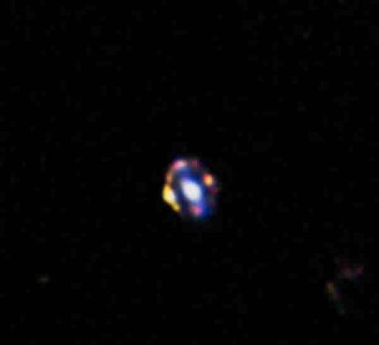 哈勃太空望远镜拍摄的这张照片揭示了目前发现的最遥远的引力透镜。图片中央发光的是一个正常星系的中央地区。意外的它与更遥远的年轻恒星形成星系精确的对齐。更遥远的天体
