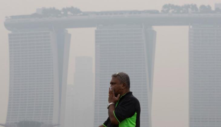 新加坡日前雾霾笼罩，男子上街要掩鼻而行。