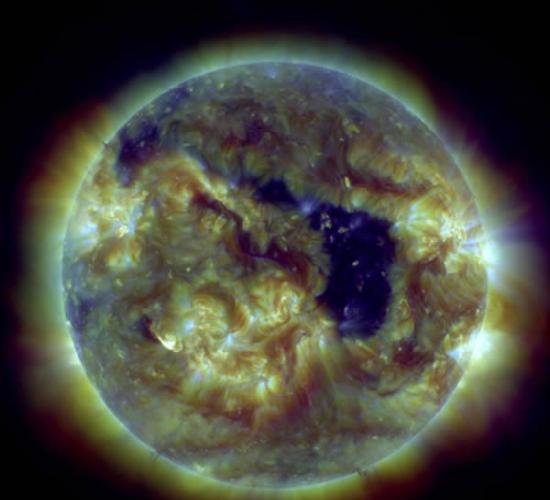 太阳动力学天文台在紫外波段拍摄的太阳图像，其中正对地球的暗黑色区域即为一个巨型冕洞
