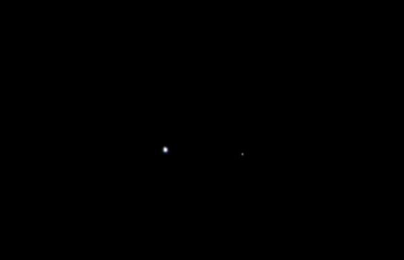 如图所示，这是2011年8月，美国宇航局“朱诺”探测器途经木星轨道拍摄的，显示出地球(图中左侧圆点)和月球(图中右侧圆点)之间的空隙。当时两颗星球相隔40200