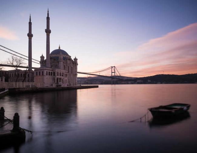 黎明为土耳其伊斯坦堡的奥塔科伊清真寺洒上玫瑰色的光辉。 附近马摩拉海里的钻孔，揭露了土耳其地底最新的缓慢滑移事件。 PHOTOGRAPH BY ROBERT H