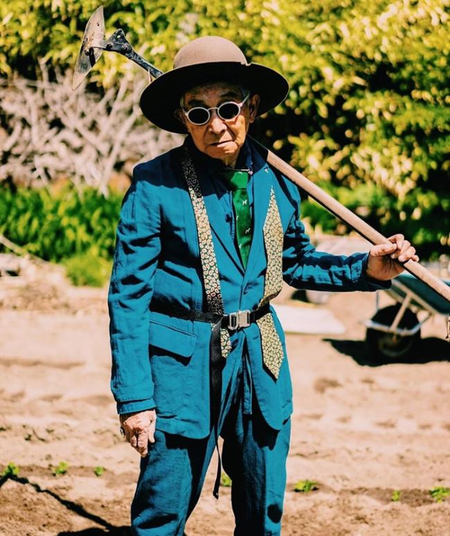 最为人注目的是一套湖水蓝的西装，配上绿色牛油果图案领带；爷爷手持铁铲架上墨镜，完全是森系格局。