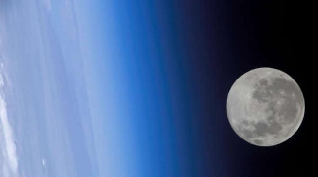 从国际太空站（International Space Station）看到的满月好像掠过了地球的大气层。 PHOTOGRAPHY BY NASA, INTERN