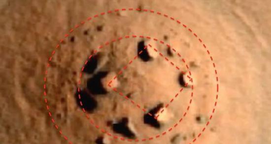 火星轨道勘测器高清晰照相机拍摄到火星地表图，从图中可以明显看出，在隆起的小山丘上，有一个环形石阵。
