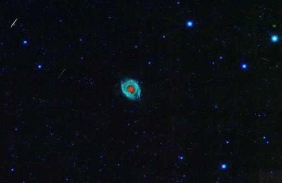 一颗小行星划过螺旋星云NGC 7293附近的夜空