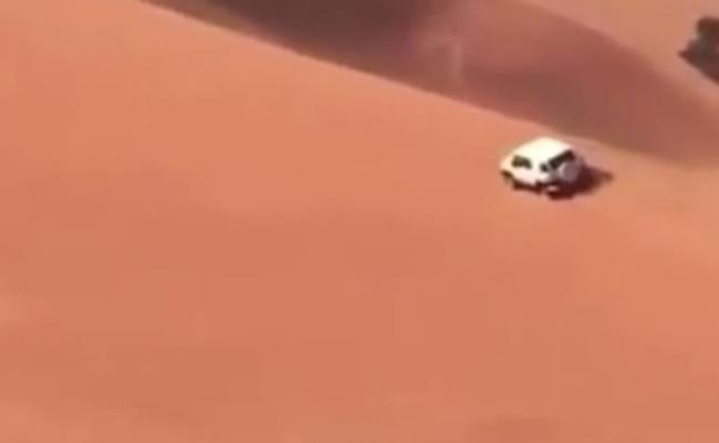 越野车驶向沙丘顶部。