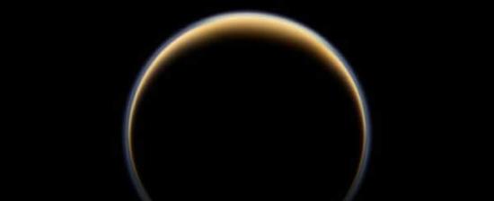 美国宇航局卡西尼探测器观测土卫六背面，发现阳光散射穿入土卫六大气层边缘并形成一个色彩环