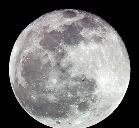 摄影师安迪-史密斯拍摄的一幅精彩作品，展示国际空间站在月球前方穿过的壮观景象。照片中，这个距地面260英里(约合420公里)的轨道前哨变成一个小黑点，就像是夜空