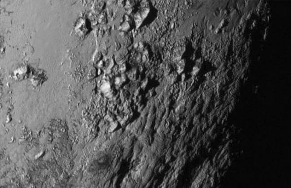 图中是首张冥王星高清图像，呈现其表面存在冰水和山脉。目前物理学家认为，冥王星次表面海洋潜藏着生命形式。