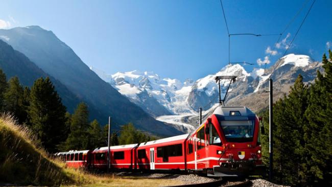 一列火车正从瑞士白雪皑皑的山峦间缓缓驶过。搭火车不仅能尽情欣赏景致，又能减少碳足迹。 PHOTOGRAPH BY SCULPIES, GETTY IMAGES
