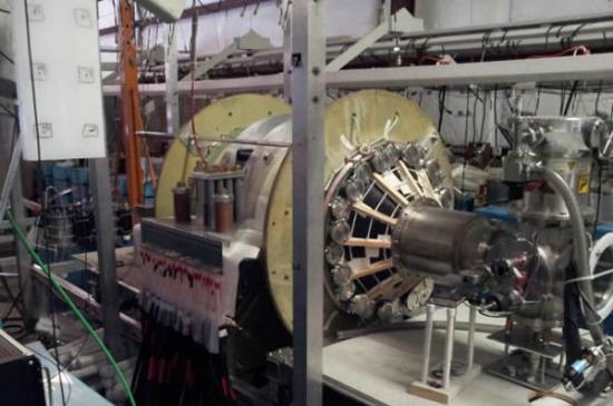 这是华盛顿大学等离子体动力学实验室的核聚变火箭测试舱。图中绿色的真空舱被两个大型的高强度铝磁铁包裹。电磁铁系统则由强大的电容供电，大量电线连接着各个系统。