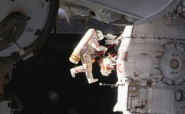 宇航员在宇宙空间漫步，为空间站进行维修。