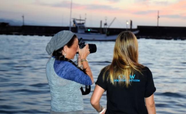 有外国女子用相机拍摄出海围捕时的情景。