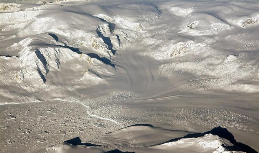 “冰桥行动”研究飞行中所看到的夕阳之下的冰川与山脉。