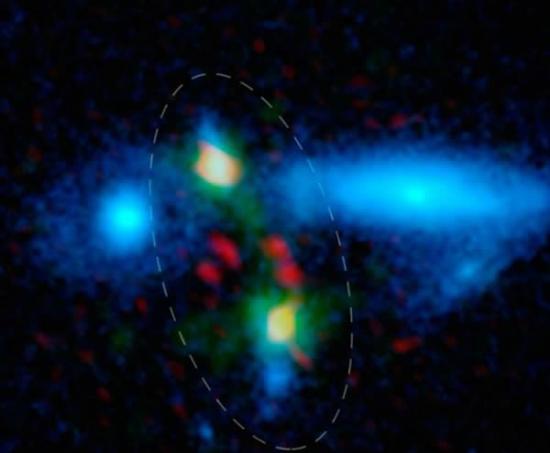 这张图片显示了美国夏威夷莫纳克亚山顶史密森天体物理天文台亚毫米阵列（SMA）拍摄的特写镜头，圆圈中是合并星系，显示尘埃环绕的恒星形成区域。绿色的数据是由美国新墨