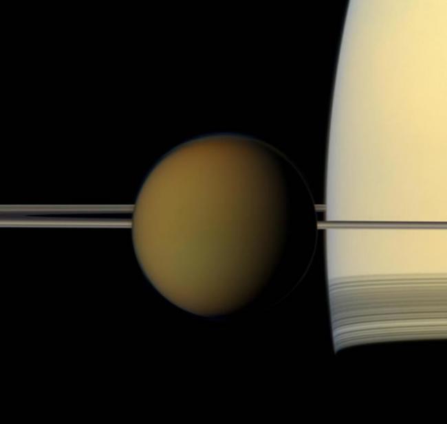 从这张美国航太总署（NASA）卡西尼号太空船所拍摄的全彩影像中，可以看到土星最大的卫星――土卫六，正经过土星和土星环的前方。 PHOTOGRAPH BY NAS