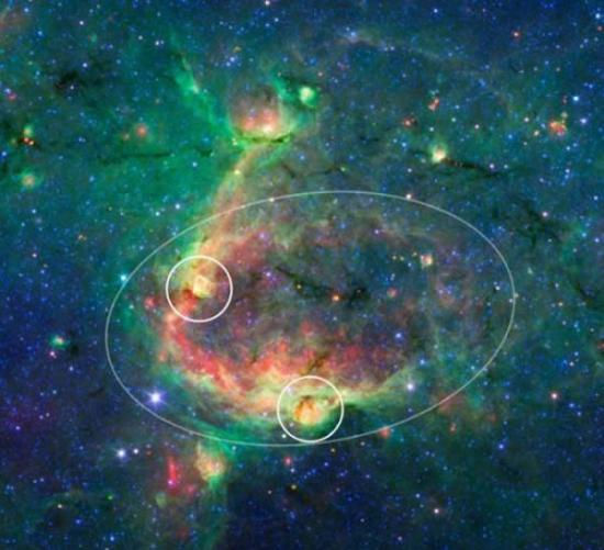 一幅展示层泡结构的红外图像。在这种结构中，一个巨大“气泡”――由大质量恒星形成――触发了较小“气泡”的形成。这个大“气泡”占据了图像的中央区域，由它产生的两个小