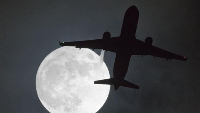 客机飞快掠过月亮。