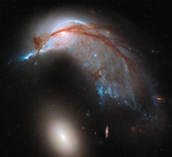 图片显示两个星系正相互作用。曾经的标准旋转星系NGC2936以及较小的椭圆星系NGC 2937，看起来异常类似一只企鹅正在守护自己的蛋。