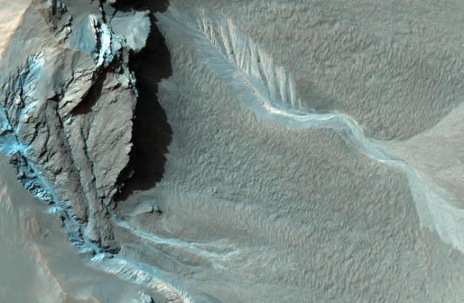 在哈尔坑的西北缘，有许多沟渠蜿蜒而下。目前还不清楚这些沟渠是如何形成的，不过有些沟渠和地球上由液态水冲蚀而成的地形很类似。 PHOTOGRAPH BY NASA