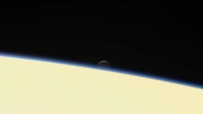 美国航太总署的卡西尼号太空船在2017年9月15日冲入土星自毁，这张影像是卡西尼号所拍摄的告别作之一，可以看到冰冷的土卫二沉没在土星后方。 PHOTOGRAPH