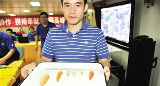生物学家刘诚刚展示“蛟龙”号生物诱捕装置捕获的端足类生物。