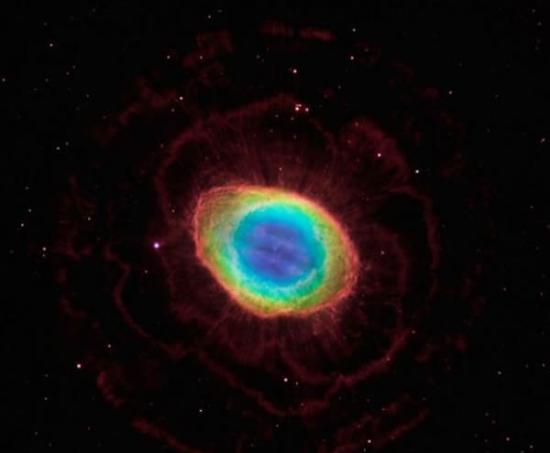 环状星云的合成图像，结合了哈勃望远镜宽视场照相机3号以及美国亚利桑那州的大双筒望远镜获取的新观测数据。在这幅图像中，色彩绚烂的环状星云与周围的暗淡太空形成鲜明颜