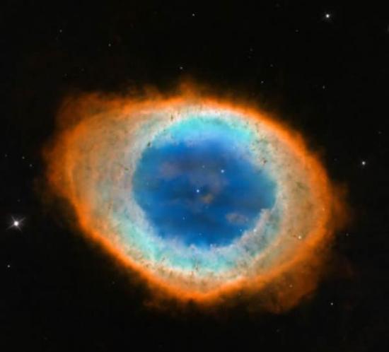 环状星云(也被称之为“Messier 57”)图像，展示了生动的外形和色彩。从地球的角度观察，这个星云呈简单的椭圆外形，边缘较为粗糙。根据哈勃太空望远镜以及一些
