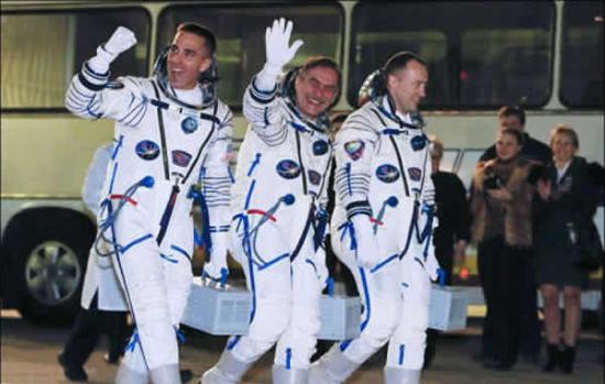 俄宇航员米苏尔金(右)与维诺格拉多夫(中)以及美国宇航员卡西迪前往乘坐飞船。