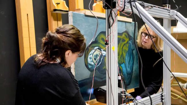 西北大学的艾米琳．普叶（左）与安大略美术馆的珊卓．韦布斯特库克架设了X射线萤光仪来扫描毕卡索的画作〈蹲坐的行乞者〉。 PHOTOGRAPH COURTESY A
