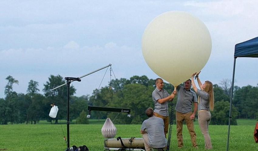 图中是工作人员正在对运送骨灰的气象气球充气，它将携带装载骨灰的折纸状容器进入太空边缘。