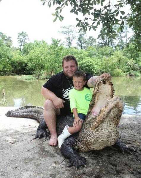 麦克和它的儿子布莱斯坐在一只4米多的鳄鱼身上。