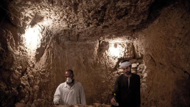 两位工人正在清理一具在埃及路克索找到的古代木乃伊。 PHOTOGRAPH BY NARIMAN EL-MOFTY, AP FOR NATIONAL GEOGRA