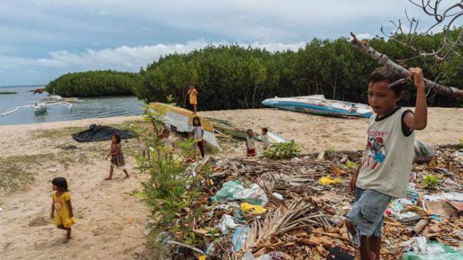 孩童在菲律宾保和岛的一个垃圾堆旁边玩耍。在大潮或下雨的时候，这里的垃圾会溢流到海里。菲律宾是全球海洋生物多样性的中心，但在污染海洋方面，也仅次于中国与印尼，全球