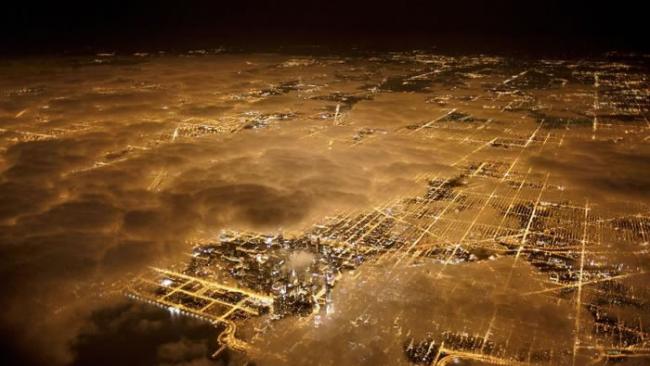 芝加哥夜晚空拍图,就算有云层笼罩,仍难掩城市光害。 / PHOTOGRAPH BY JIM RICHARDSON, NATIONAL GEOGRAPHIC CR