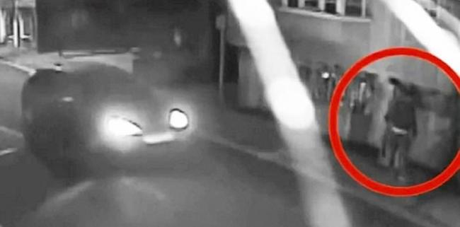疑犯（红圈示）看到汽车驶过时，会停手扮作若无其事。