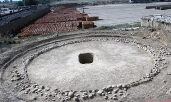墓室外观为圆形，多个小石在圆形外侧围起。