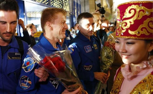 皮克（左二）早前于哈萨克降落，并接受献花。