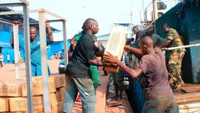 工人由渔船搬下一箱箱的物品。