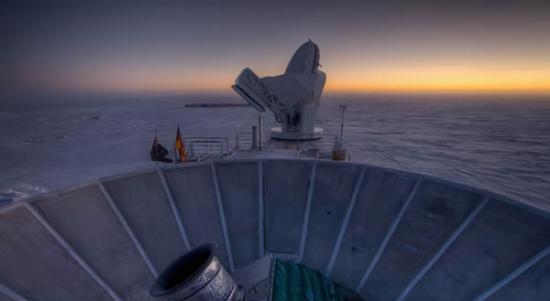 太阳在BICEP2（前景）与南极望远镜后方落下。 PHOTOGRAPH BY STEFAN RICHTER, HARVARD