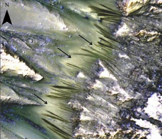 美国宇航局火星勘测轨道飞行器上的“高精度科学实验成像”拍摄的这张图片显示，深色的季节性流动纹路呈发射状从这颗红色行星的帕利基尔陨石坑裸露在外的岩床向外延伸出来
