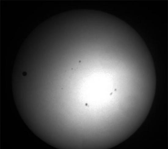 2012年6月6日的金星凌日，最左侧的圆形黑点是金星，其他黑色斑点是太阳黑子。