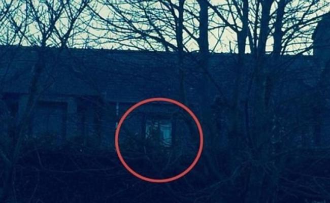农夫早前拍摄了一张农舍的照片，发现窗边有道黑影（红圈示）。