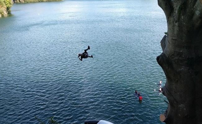 坐在巨型浮床上的人被弹飞上高空再堕入湖中。