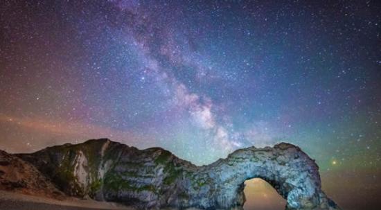 斯蒂芬・班克斯（Stephen Banks）拍摄的这张照片显示杜德尔门的天然岩石拱门定格了遥远银河系带。杜德尔侏罗纪海岸的岩石形成已经有1亿多年的历史，但组成银