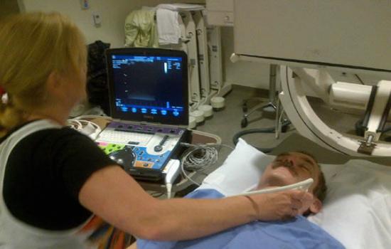 技术人员正在对克里斯・哈德菲尔德的脊椎进行超声波检测，主要关注于他头部和颈脖的椎骨。