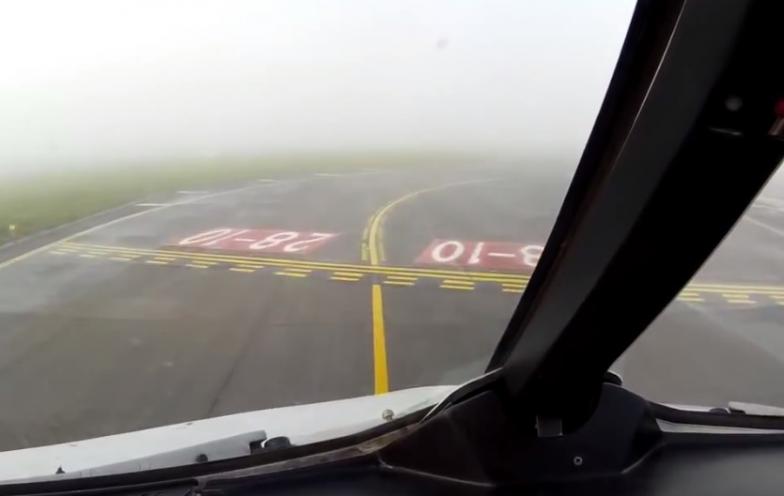 飞机安全降着陆后在跑道上滑行，稍远处视野仍被大雾遮掩。