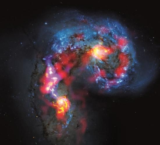 这一对距离地球7000万光年的触须星系彼此碰撞的画面，结合了哈伯太空望远镜捕捉到的可见光（蓝色），以及ALMA望远镜的一张测试影像中所拍摄到、前所未见的星际气体