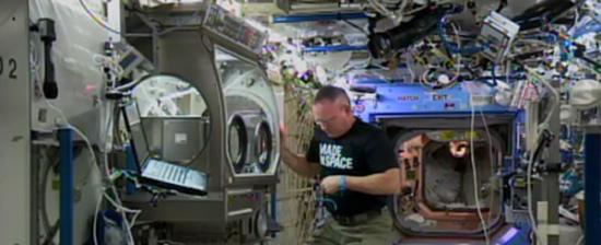 国际空间站司令官巴里・布切・威尔莫（Barry Butch Wilmore）在国际空间站的微重力科学手套箱里安装3D打印机