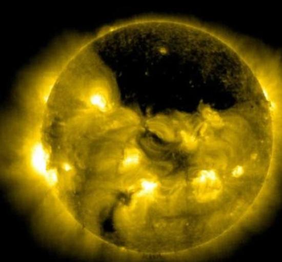 由太阳和日光层探测器拍摄到的太阳极区冕洞现象，这里的温度比周围要低一些